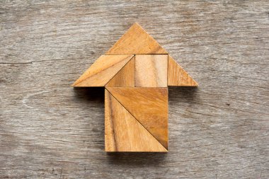 Tangram bulmacanın ahşap arka plan üzerinde ok şeklinde