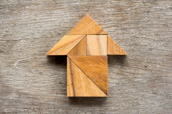 Tangram puzzle ve tvaru šipky na dřevěné pozadí — Stock fotografie