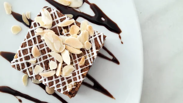 Vista superior do brownie de chocolate com amêndoa fatiada no fundo placa branca — Fotografia de Stock