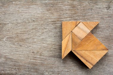 Tangram bulmacanın ahşap arka plan üzerinde ok şeklinde