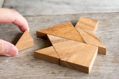 Yapı rüya ev veya mutlu yaşam konsepti için ev şekli yerine getirmek için ahşap tangram bulmacanın bekle