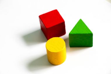 Beyaz arka plan üzerinde renkli ahşap şekil oyuncak (kare, üçgen, yuvarlak) kümesi