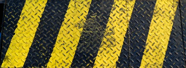 Peinture de ligne noire et jaune sur fond métallique antidérapant — Photo