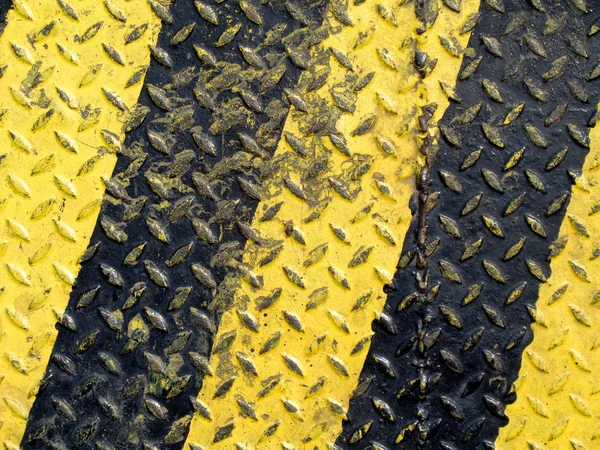 Черная и желтая линия краски на нескользящем металлическом фоне — стоковое фото
