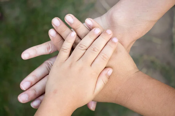 Актуальность рук взрослой азиатки и двух детей группы вместе для поддержки — стоковое фото