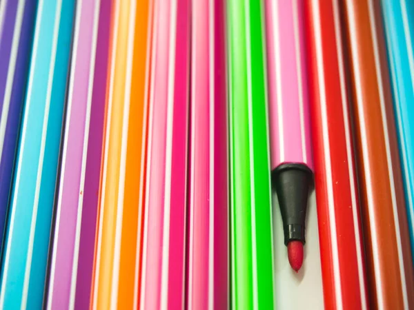 Fila de caneta de várias cores com um que diferenciam — Fotografia de Stock