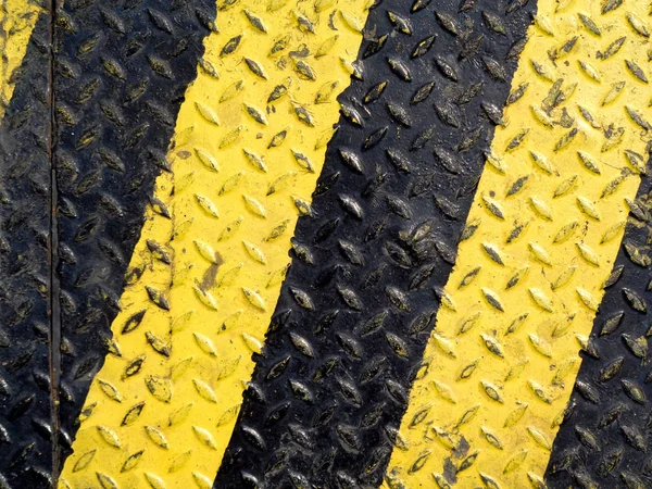 Black and yellow line paint on non-slip metal background