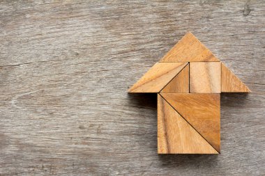 Tangram bulmacanın ahşap arka plan üzerinde ok şeklinde