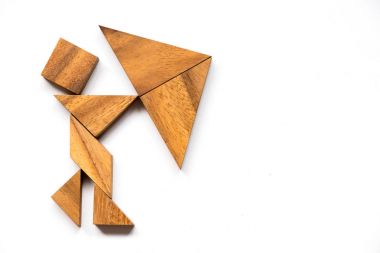 Adam olarak ahşap tangram beyaz arka plan üzerinde şemsiye şekli tutun (iş olarak kavram vardır kriz)