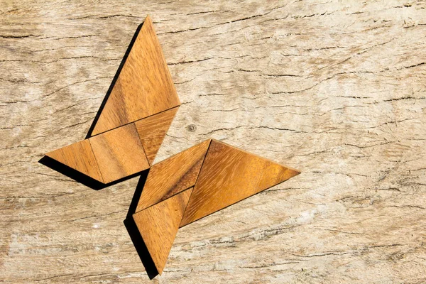 Ξύλινα tangram παζλ στην πετούν πεταλούδα σχήμα φόντου — Φωτογραφία Αρχείου