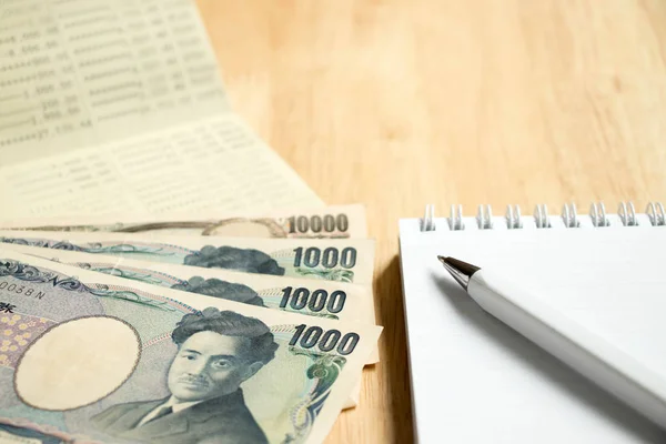 Bankpassbok med japanske yen og bok med penn på trebordsbakgrunn – stockfoto