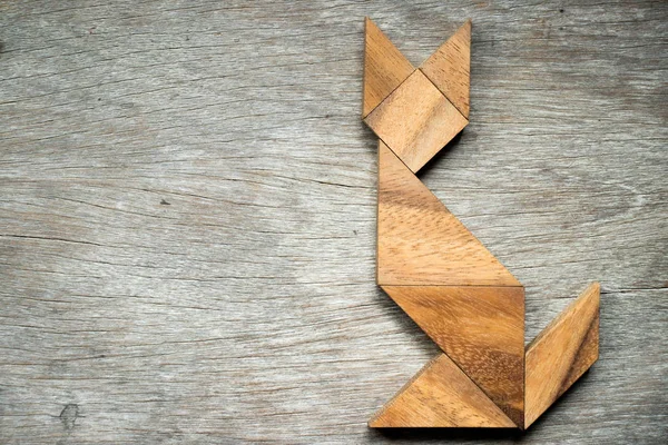 Tangram puzzle ve tvaru kočky na dřevěné pozadí — Stock fotografie