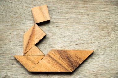 Tangram bulmaca adam yelken tekne şekli ahşap arka plan üzerinde