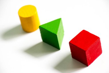 Beyaz arka plan üzerinde renkli ahşap şekil oyuncak (kare, üçgen, yuvarlak) kümesi