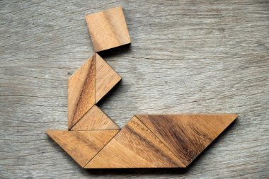 Tangram bulmaca adam yelken tekne şekli ahşap arka plan üzerinde