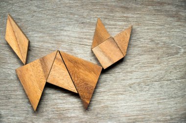 Tangram bulmacanın ahşap arka plan üzerinde kedi şeklinde