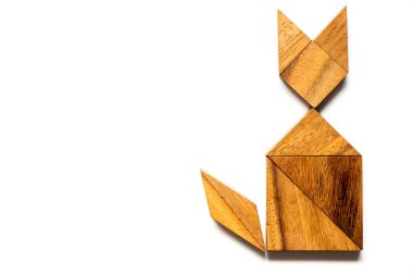 Ahşap tangram bulmacanın içinde şekil beyaz arka plan üzerinde oturan kedi