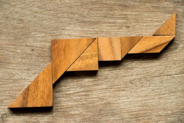 Ahşap tangram bulmacanın silah şekli arka planda