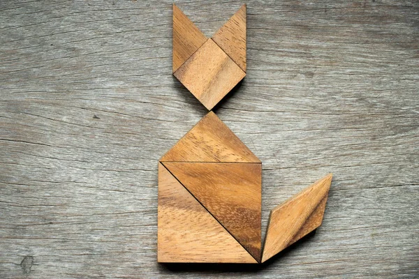 Tangram puzzle ve tvaru kočky na dřevěné pozadí — Stock fotografie