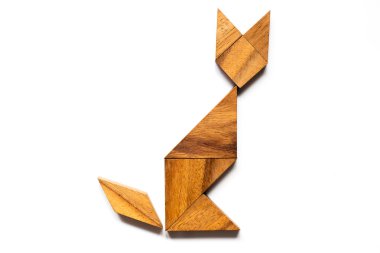 Ahşap tangram bulmacanın içinde şekil beyaz arka plan üzerinde oturan kedi