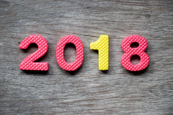 Toy foam alphabet in wording 2018 on wood plate background (Conc — Stock Photo, Image