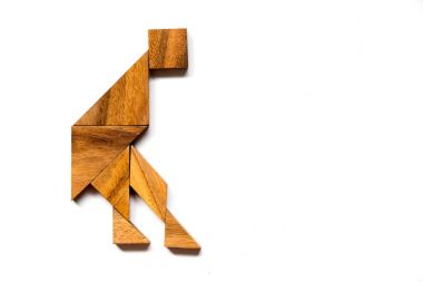 Adam şekli beyaz arka plan üzerinde dans ahşap tangram bulmacanın