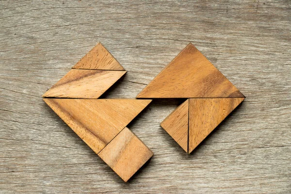 Ahşap tangram bulmacanın arka planda ayrı kalp şekli (kavramı aşk tam için ilişki kırık evlilik boşanma)