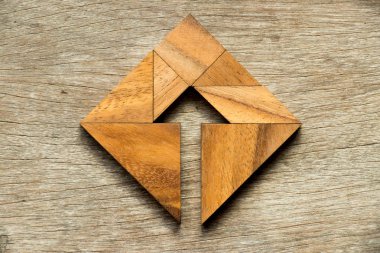 Ahşap arka plan içinde ok sembolü ile kare şeklinde bulmaca Tangram