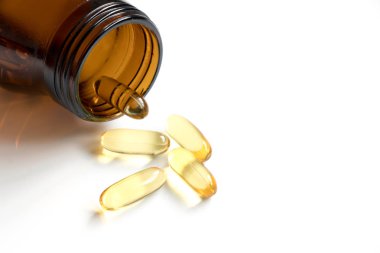 Sarı yumuşak, jelatin beyaz arka plan üzerinde kehribar şişe ile kapsül ve metin eklemek için kopya alana sahip