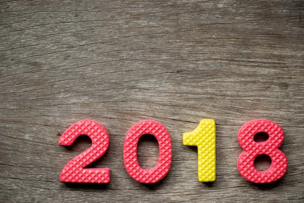 Toy foam alphabet in wording 2018 on wood plate background (Concept for Happy new year decoration) — Stock Photo, Image