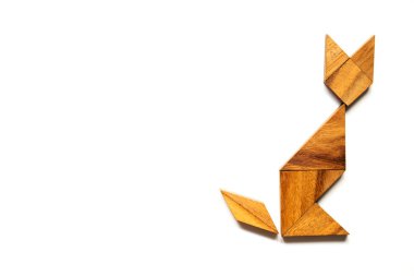 Ahşap tangram bulmacanın içinde şekil beyaz arka plan üzerinde oturan kedi