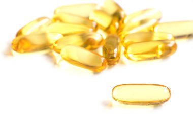 Beyaz arka plan (tıp, ilaç, beslenme ek kavramı üzerinde sarı renkli yumuşak jelatin kapsül)