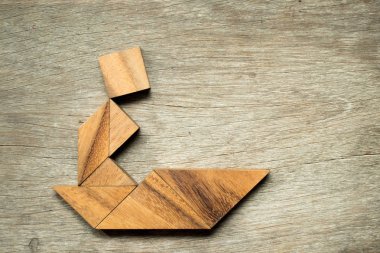 Tangram bulmaca adam yelken tekne şekli ahşap arka plan üzerinde