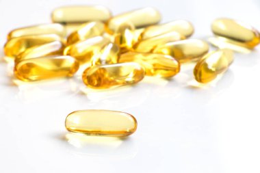 Beyaz arka plan (tıp, ilaç, beslenme ek kavramı üzerinde sarı renkli yumuşak jelatin kapsül)