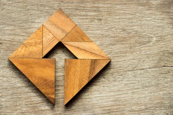 Ahşap arka plan içinde ok sembolü ile kare şeklinde bulmaca Tangram