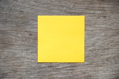 Sarı renk kağıt eklemek anımsat veya Not için ahşap arka plan üzerinde