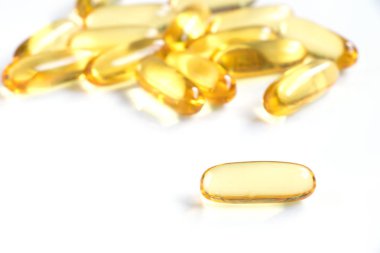 Beyaz arka plan (tıp, ilaç, beslenme ek kavramı üzerinde sarı renkli yumuşak jelatin kapsül)