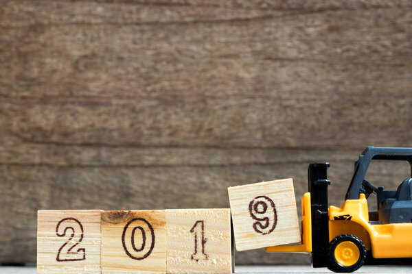 Игрушечный пластиковый вилочный захват блок сочинять и выполнять формулировки 2019 года на деревянном фоне
