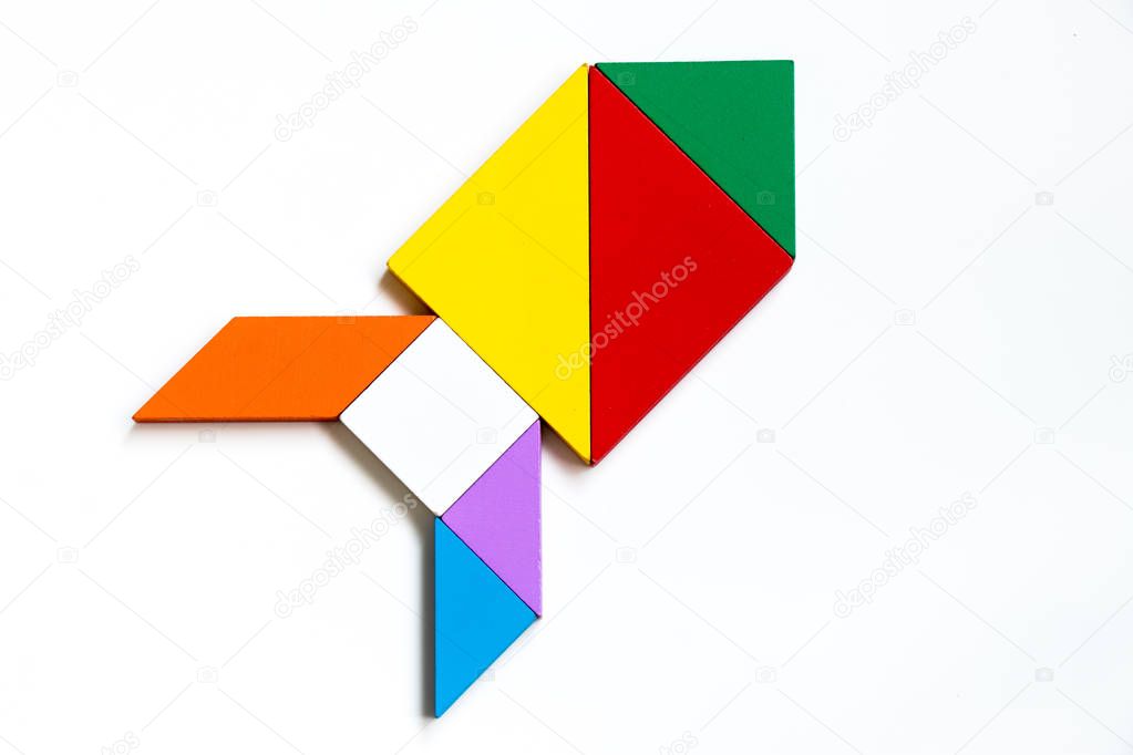 Colorful wood tangram puzzle in rocket or missile shape on white background