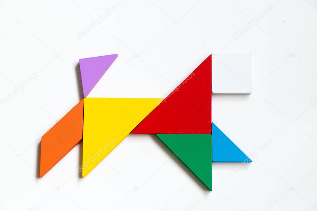Colorful wood tangram puzzle in running dog shape on white background