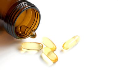 Sarı yumuşak, jelatin beyaz arka plan üzerinde kehribar şişe ile kapsül ve metin eklemek için kopya alana sahip