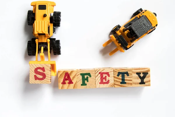 Zabawki z tworzyw sztucznych spychacz przytrzymaj toy block list s spełnić słowo bezpieczeństwa z wózka widłowego na białym tle — Zdjęcie stockowe