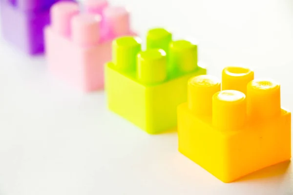 Multi color square plastic toy block on white background
