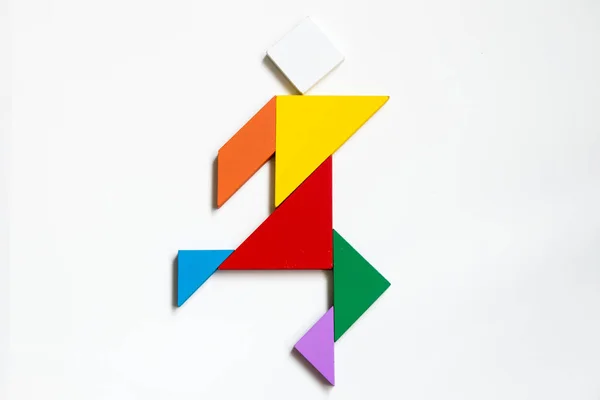 Color wood tangram puzzle on human walking shape on white background