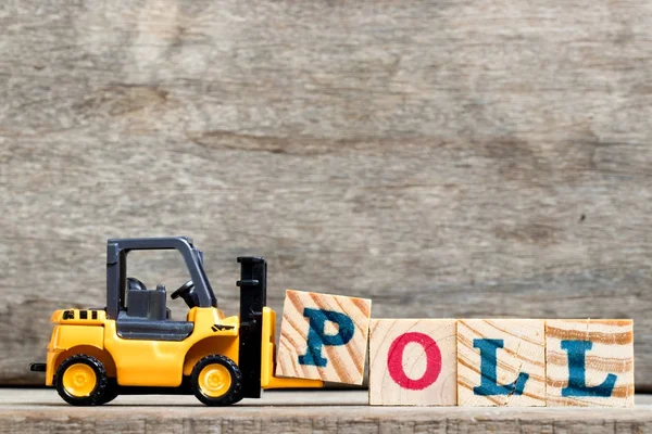 Yellow plastic forklift hold letter P to complete word poll on wood background — Stock Photo, Image