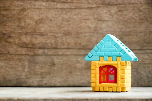 Modelo de rompecabezas en forma de hogar sobre fondo de madera —  Fotos de Stock