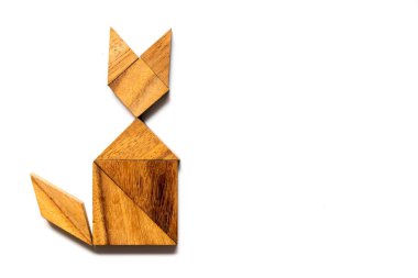 Ahşap tangram bulmacanın içinde şekil beyaz arka plan üzerinde oturan kedi