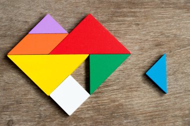 Renkli tangram bulmacanın ahşap arka plan (mutlu aile, sevgi yerine getirilmesi kavramı yerine getirmek için kalp şekli bekleyin)
