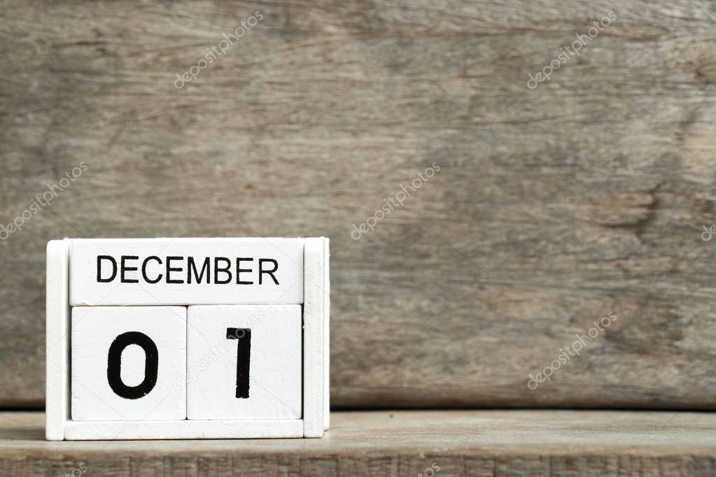 White block calendar present date 1 and month December on wood background