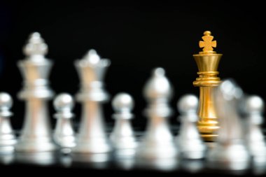 Blaack arka plan (konsept şirket stratejisi, iş zafer veya karar için başka bir gümüş takım ile satranç oyun yüzüne altın Kral)